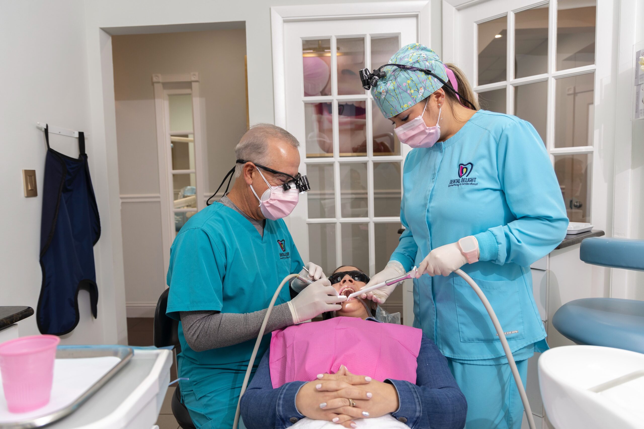 Dr. Miguel Reyes y Dra. Christina Reyes realizando tratamiento dental en Dental Delight, Hialeah – atención profesional y familiar en un ambiente moderno.